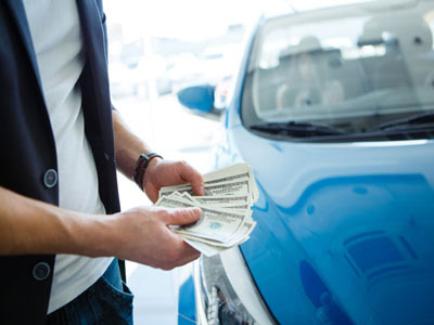 Man with money in hand next to clunker